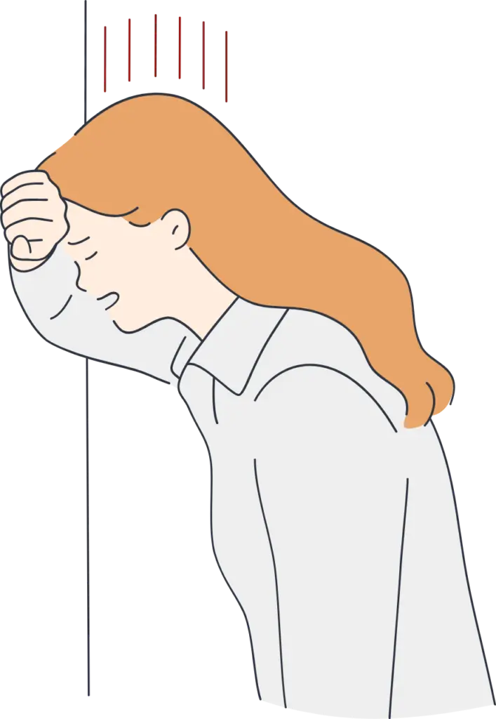 壁に持たれて落ち込む女性